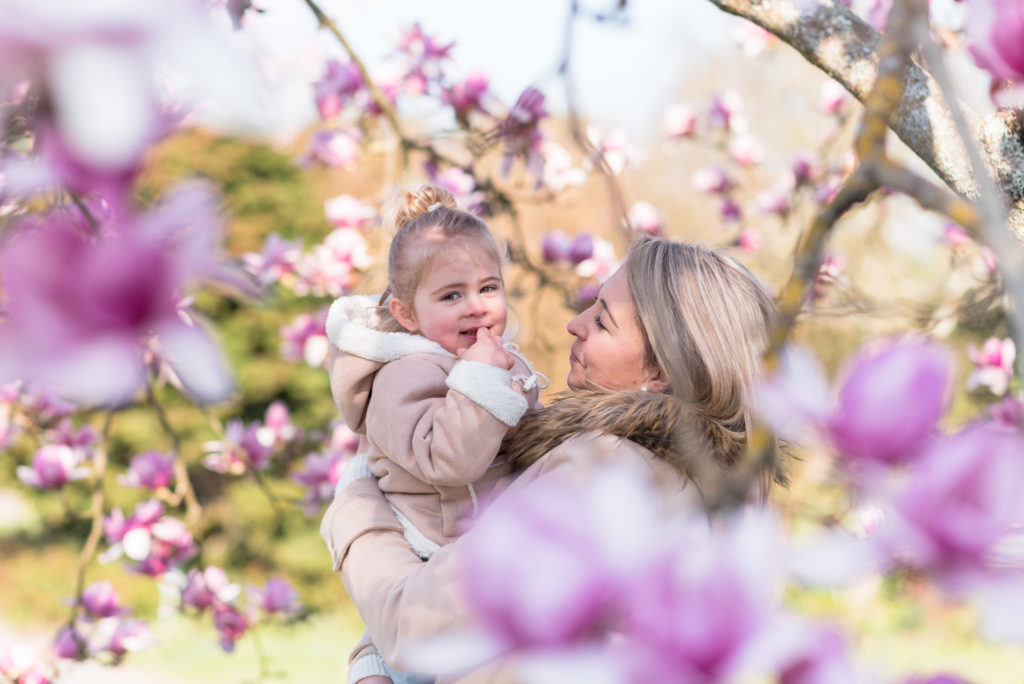 Maman tenant sa fille dans les bras dans un magnolia
