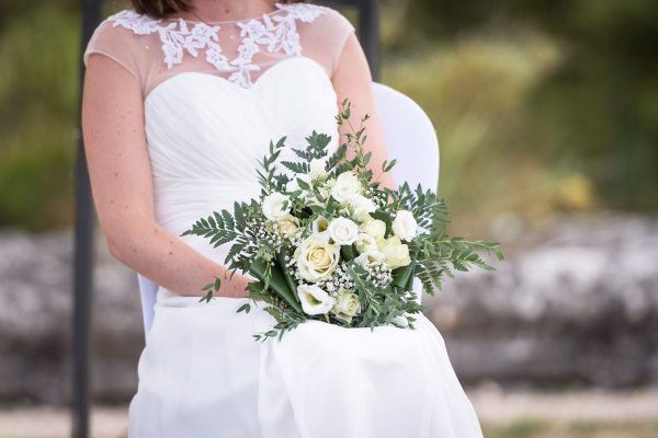 Bouquet de la mariée sur ses genoux dans les couleurs verts et blanche