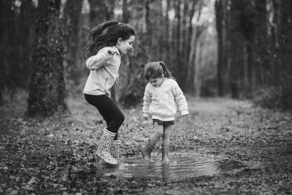 Enfants sautant dans une flaque en botte, photo en noir et blanc
