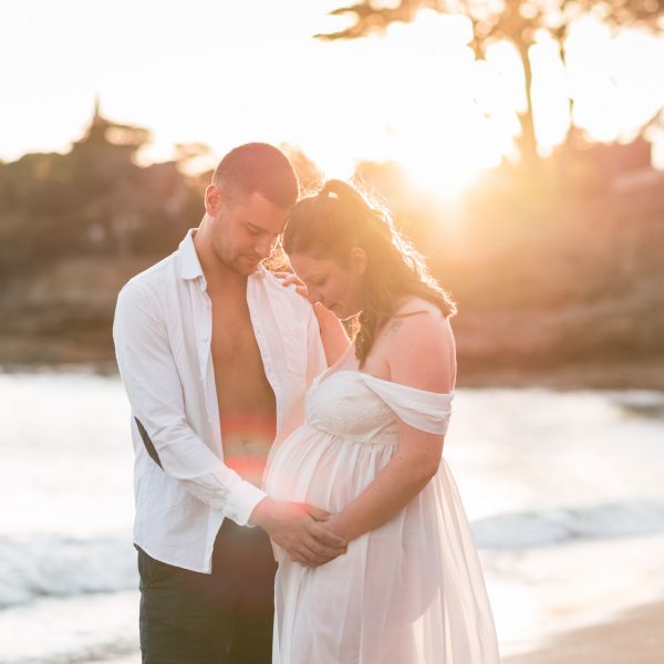 Séance grossesse en couple au coucher du soleil, avec chemise et robe blanche