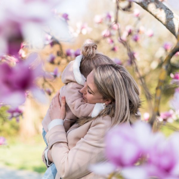 Maman tenant sa fille dans les bras dans les magnolias