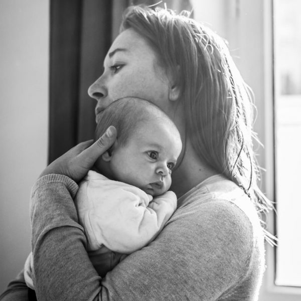 Photo en noir et blanc d'un bébé dans les bras de sa maman